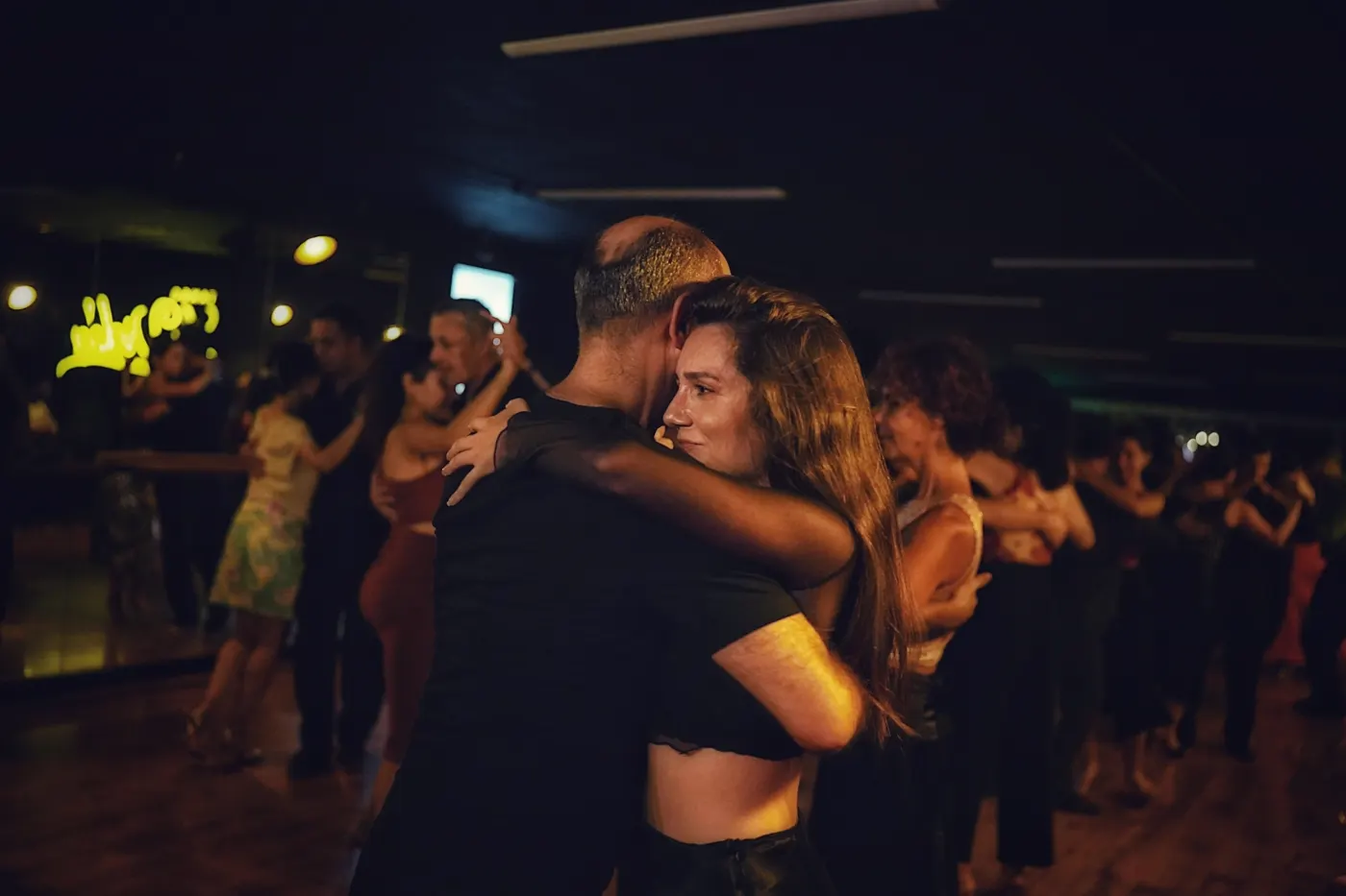 Dancers sharing an embrace in a busy evening class